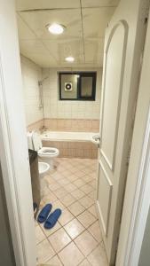 a bathroom with a toilet and a tub and a sink at Golden Horse Hostel in Dubai