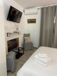 een slaapkamer met een bed en een tv aan de muur bij La Chambre du Patio in Le Luc