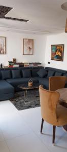 a living room with a blue couch and a table at BRIECH HOUSE in Asilah