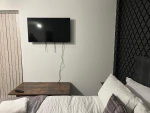 a bedroom with a bed and a tv on the wall at Luxury Studio Apartment in Manchester