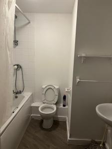 a white bathroom with a toilet and a sink at Luxury Studio Apartment in Manchester