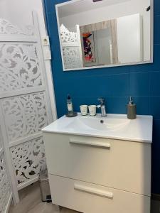 uma casa de banho com um lavatório branco e um espelho. em La Chambre du Patio em Le Luc