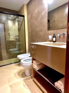 W łazience znajduje się umywalka, toaleta i lustro. w obiekcie Hotel Cerros del Norte w mieście Tilcara