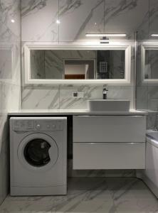 a kitchen with a washing machine and a sink at Apartament Pogodno in Szczecin