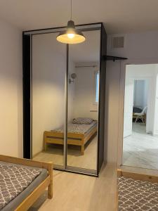 a mirror in a room with two beds and a room at Apartament Pogodno in Szczecin
