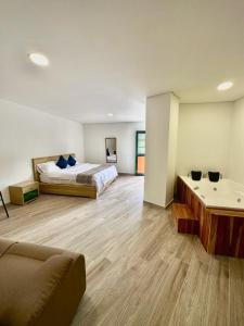 Habitación grande con 2 camas y sofá en ALTO VERDE HOTEL, en Guatapé
