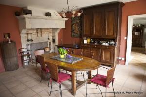 a kitchen with a table and chairs and a fireplace at Le Relais du Passe-Heures in Cenans