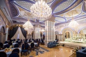 um salão de banquetes com lustres e mesas num casino em WA Hotel em Jidá