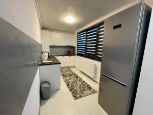 Elle comprend une petite cuisine avec un réfrigérateur et une fenêtre. dans l'établissement D&D New Residence, à Piteşti