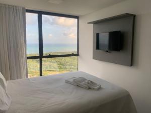 a bedroom with a bed with a flat screen tv at BARRA FLATS BY LOUI in Recife