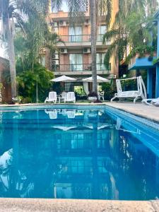 a swimming pool with two lawn chairs and a hotel at AGUAMARINA SPA Y APART in Formosa
