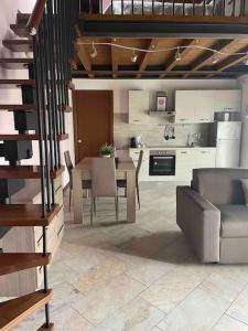 een keuken en woonkamer met een tafel en stoelen bij Appartamento vicino Forum Assago & Humanitas in Rozzano