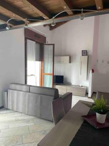 een woonkamer met een bank en een tafel bij Appartamento vicino Forum Assago & Humanitas in Rozzano
