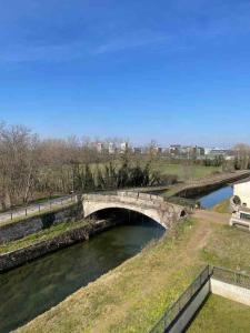 een brug over een rivier in een park bij Appartamento vicino Forum Assago & Humanitas in Rozzano
