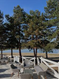 a group of chairs and trees next to a white fence at Garni hotel Oblačinsko jezero in Oblačina