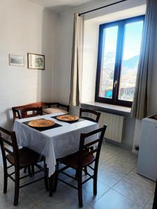una sala da pranzo con tavolo, sedie e finestre di Camere Villa Lunardini a Frassinetto