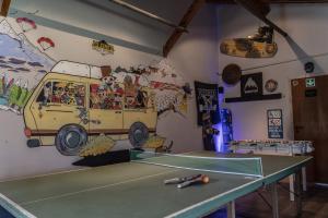 una mesa de ping pong con un mural de una furgoneta en La Finca Hostel de Montaña - Habitación Laguna en San Carlos de Bariloche