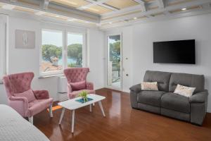 sala de estar con sofá, 2 sillas y TV en Hotel Tomi en Portorož