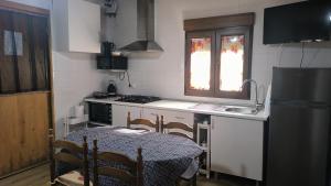 een keuken met een tafel, een wastafel en een fornuis bij Pontevedra's House in Pontevedra