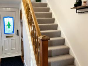 a stairway with a wooden rail and a glass window at Beautiful 3 Bedroom House in Chester Le Street in Chester-le-Street