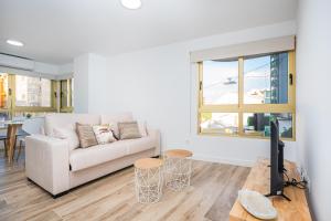 a living room with a white couch and a television at Vila Playa in Villajoyosa