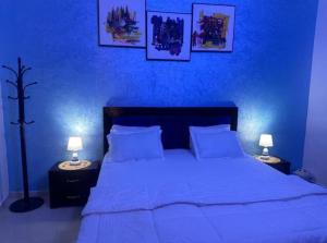 a blue bedroom with a large bed with two lamps at Studio meublé Corniche Mermoz in Dakar