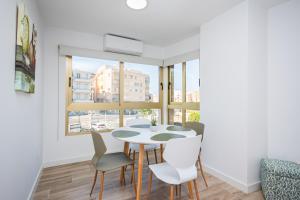 a dining room with a table and chairs and a window at Vila Playa in Villajoyosa