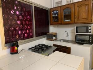a kitchen with a stove and a counter top at Studio meublé Corniche Mermoz in Dakar
