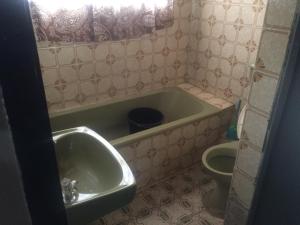 a bathroom with a tub and a sink and a toilet at ClinClia Hotel2 in Ibadan