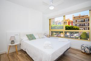a bedroom with a white bed and a large window at Vila Playa in Villajoyosa