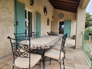 einen Tisch und Stühle auf einer Terrasse in der Unterkunft Villa Piscine Uzes à pied 6 personnes Farandole in Uzès