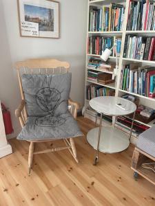 a chair and a table in a room with books at Charmerende byhus i Præstø centrum in Præstø