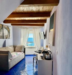 - un salon avec un canapé et une fenêtre dans l'établissement La Polena Camere Vernazza - Suite vista mare, à Vernazza
