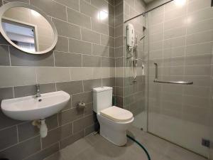 W łazience znajduje się umywalka, toaleta i lustro. w obiekcie Cozy House in Kajang w mieście Kajang