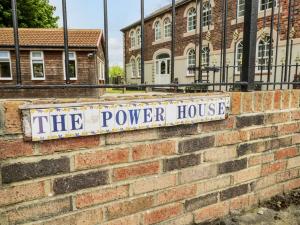 een bord voor het elektriciteitshuis op een stenen muur bij The Power House in Loftus