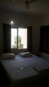 a bedroom with a large bed with a window at WeKare Archid Royal Service Apartment in Bhubaneshwar