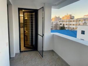 a door to a balcony with a view of a city at D&D New Residence in Piteşti