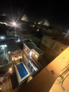una vista aérea de una casa con piscina por la noche en Pyramids Nun INN en El Cairo