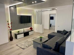a living room with a couch and a tv at D&D New Residence in Piteşti