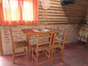 a wooden table and chairs with a cat sitting on it at SENCILLAMENTE CABAÑAS in Casa Grande