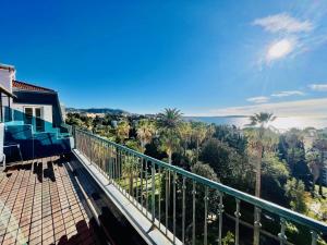 a balcony with a view of the ocean and palm trees at Palais Belle Epoque - Property With Style in Cannes