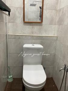 Najma guest house في Kota Bharu: حمام به مرحاض أبيض ومرآة