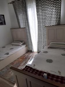 two twin beds in a room with a window at توين بماونتن فيو الساحل الشمالى in Dawwār Abū Maḩrūs