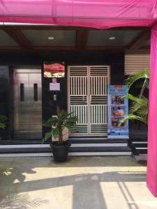 un edificio con toldo rosa y una planta delante en Ajay Residency and Convention Hall / Lodge Near Me / Lodge Rayachoti, en Rāyachoti