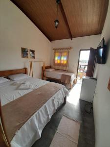 a bedroom with two beds and a television in it at CHALES DA SERRA in Bananeiras