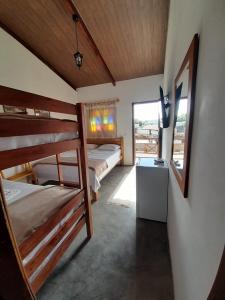 a room with three bunk beds and a window at CHALES DA SERRA in Bananeiras