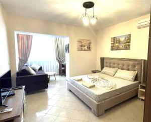 a bedroom with a bed and a living room at Peace Apartments in Durrës