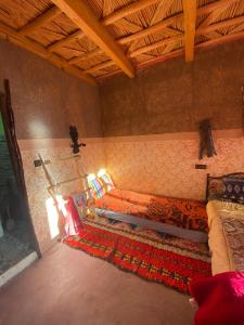 a bedroom with two beds and a rug at riad jnane imnane in Tamguist