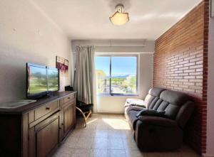 ein Wohnzimmer mit einem Sofa und einem TV in der Unterkunft Almenara Beach in Almenara