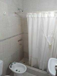 y baño con cortina de ducha y lavamanos. en Departamentos del Puerto Verde en Paraná